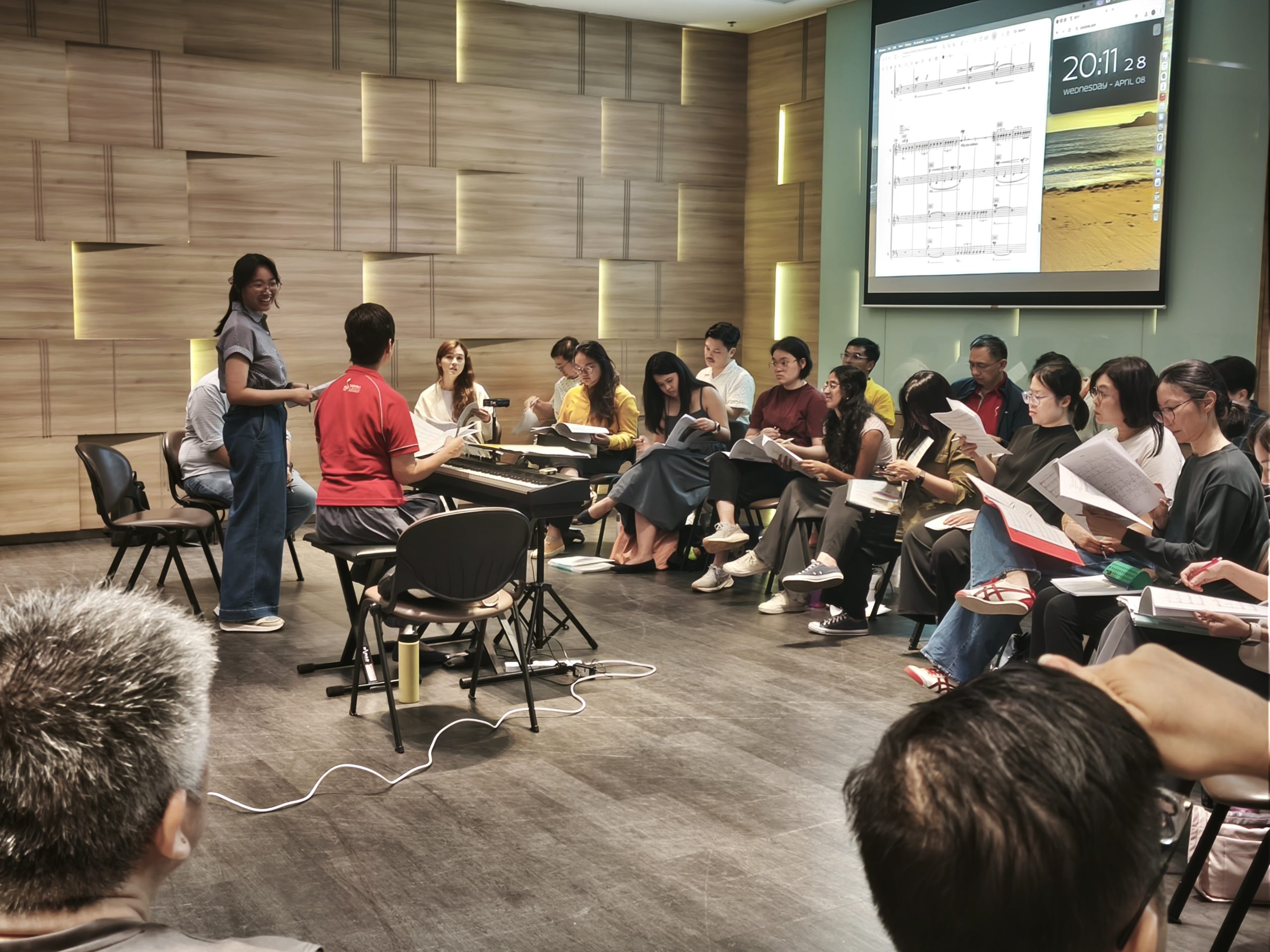 Young composer, Estene Cheong, addresses singers during score reading of her work 'Why'