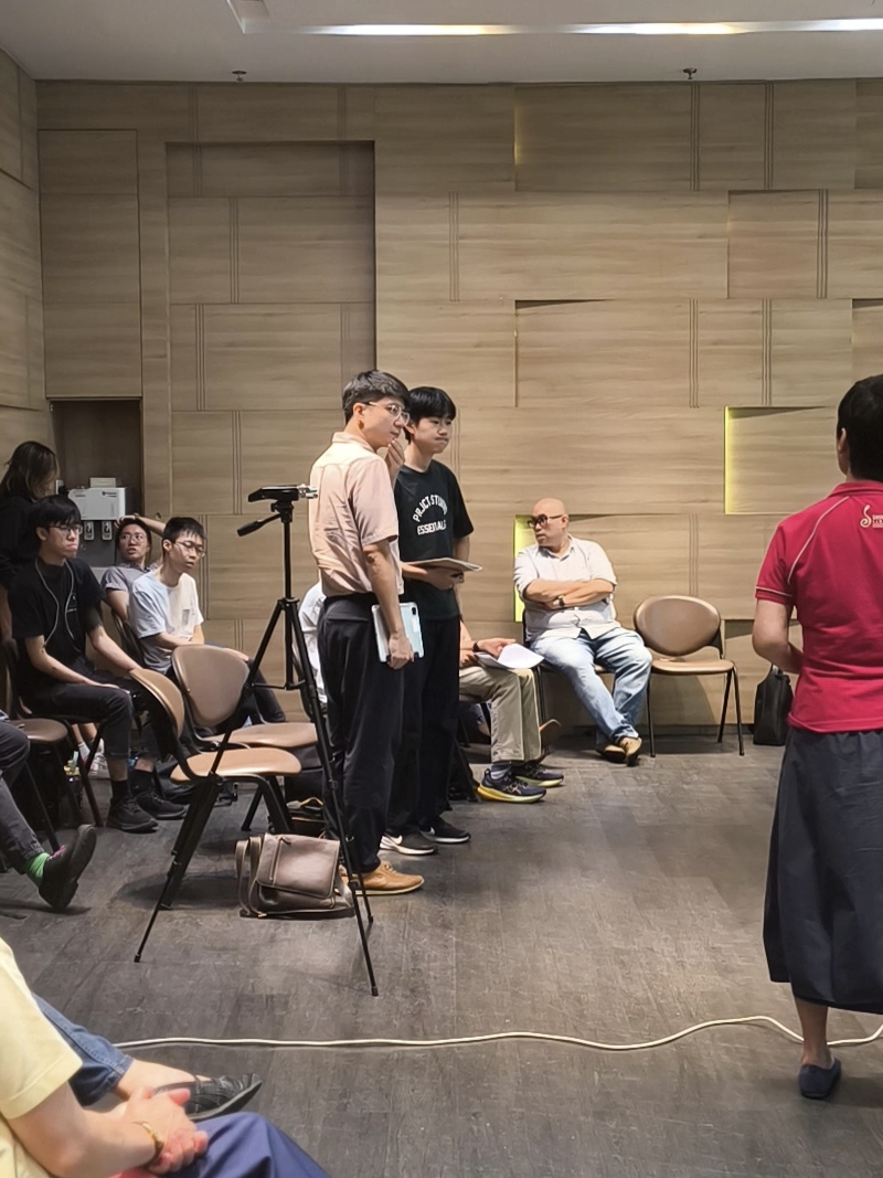 Young composer Bae Junsoo and mentor Ding Jian Han observe as SYC Ensemble Singers assume formation for rehearsal of 'luminate'